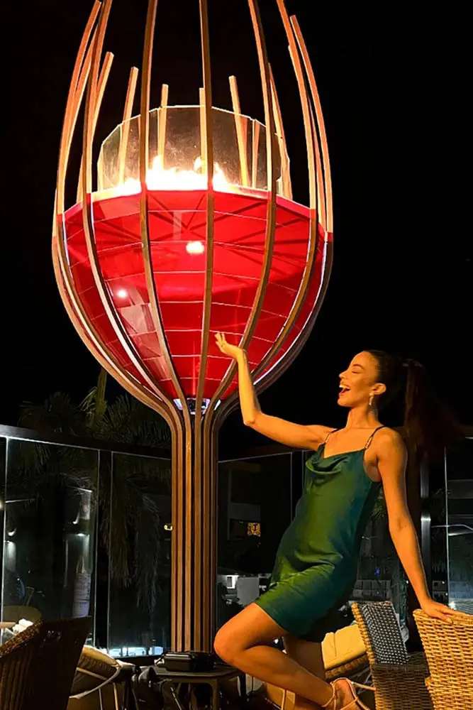 Model in front of the Florecita restaurant symbol at Playa Palmera Beach Resort by night