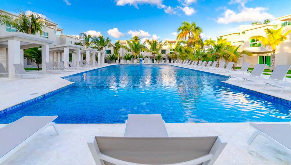 Sun loungers and pool at Beach Apartamentos Playa Palmera Beach Resort