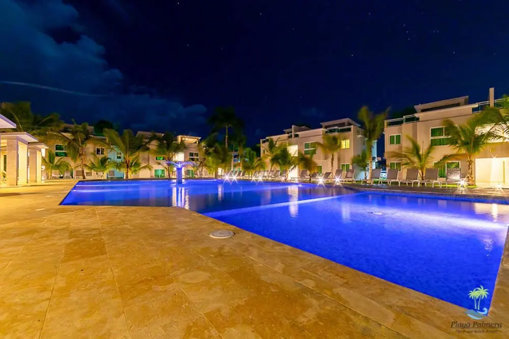 A shot of the pool at night at Beach Apartamentos Playa Palmera Beach Resort