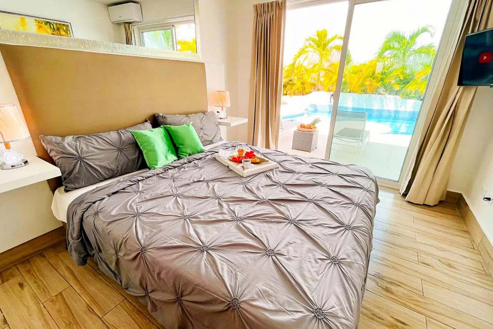 A bedroom overlooking the pool in a villa at Playa Palmera Beach Resort
