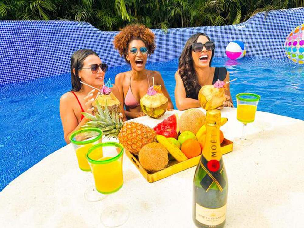 Three women sitting in the pool at the villa at Playa Palmera Beach Resort