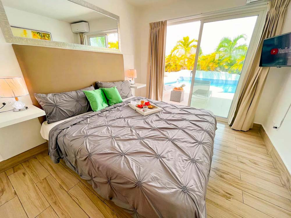 Luxury bedroom overlooking the pool in a villa at Playa Palmera Beach Resort