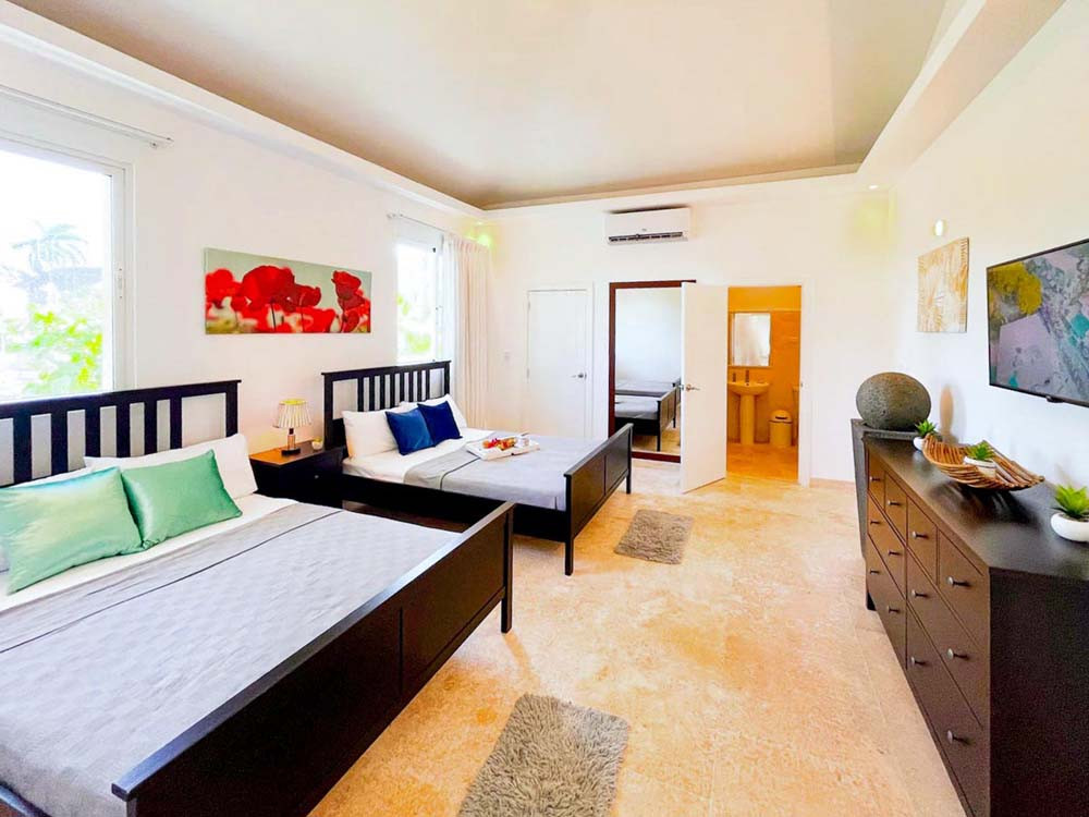 Elegant bedroom with two beds in a villa at Playa Palmera Beach Resort