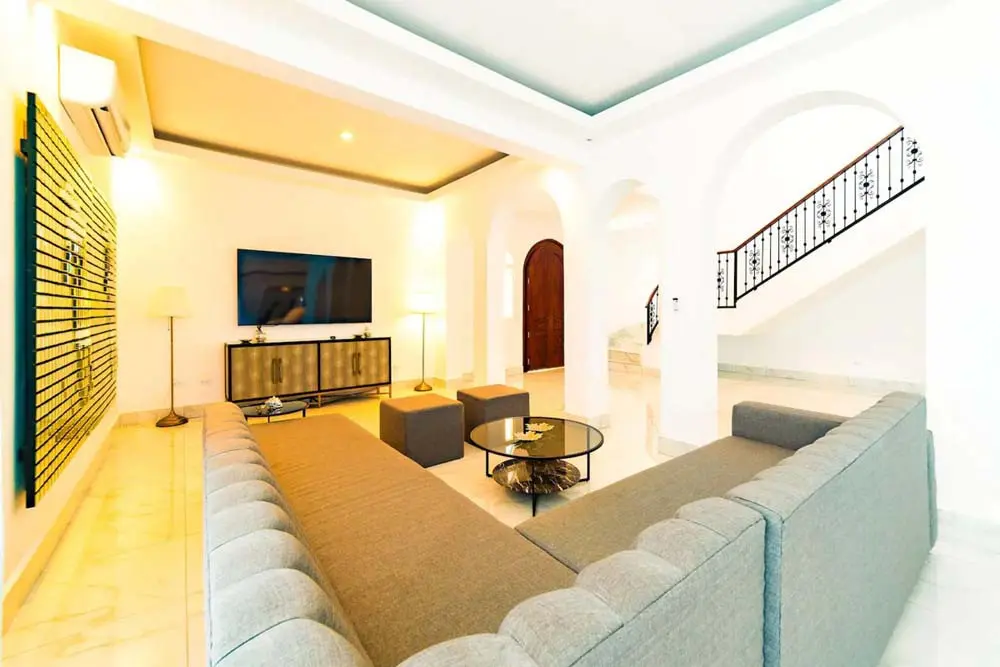 View of the spacious living room and staircase in the villa at Playa Palmera Beach Resort