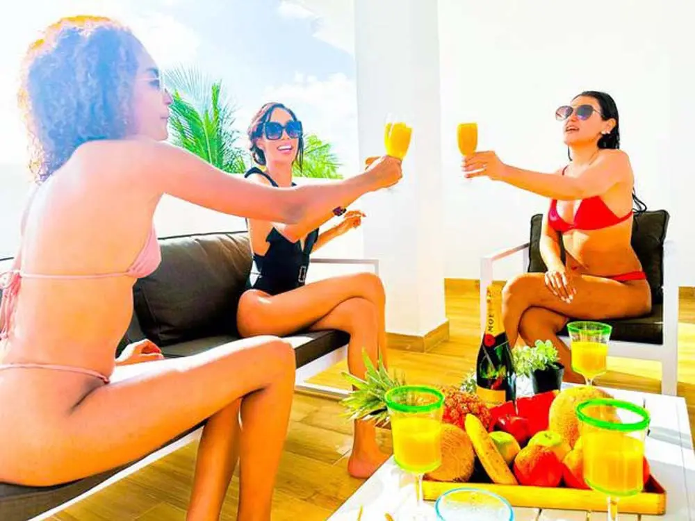 Three women sitting on the terrace of a villa at Playa Palmera Beach Resort